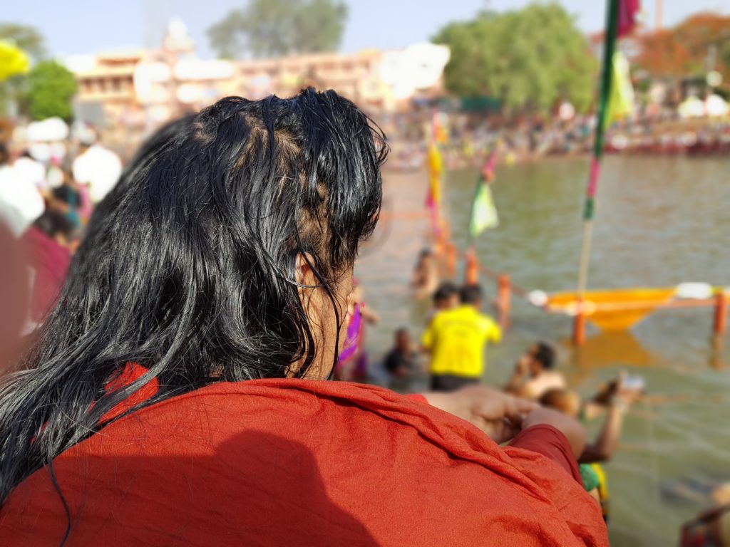 Sri Swamiji makes an offering into the river.
